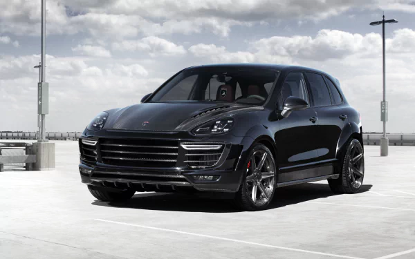 Sleek black Porsche Cayenne SUV parked on a rooftop under a cloudy sky, captured in 4K Ultra HD for a PC desktop wallpaper.