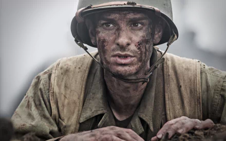 A dramatic HD wallpaper featuring Andrew Garfield as a soldier in World War II, portraying the intense atmosphere of the film Hacksaw Ridge.