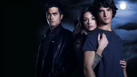 HD PC desktop wallpaper of TV show Teen Wolf: three young adults in dark clothing stand close beneath a full moon, moody blue lighting and a tense supernatural atmosphere.