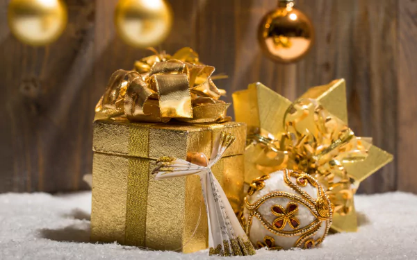HD desktop wallpaper featuring golden Christmas gifts and ornaments with a festive holiday theme against a wooden background and soft snow.