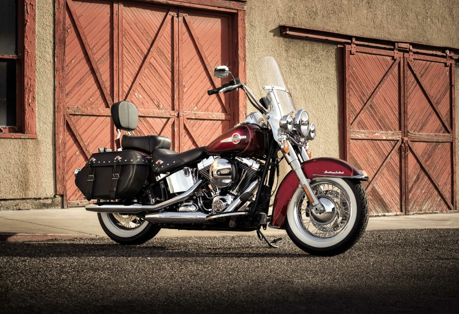 Harley-Davidson Heritage Softail Classic motorcycle parked in front of rustic garage doors — HD PC desktop wallpaper/background showcasing the Harley-Davidson Heritage Softail.