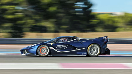 Blue Ferrari FXX K vehicle speeding along a racetrack with motion blur — 4K Ultra HD PC desktop wallpaper and background.