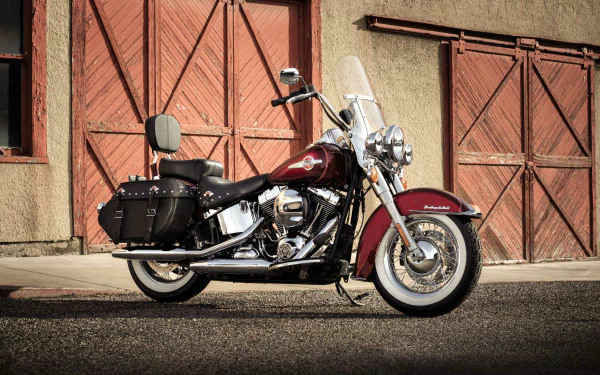 Harley-Davidson Heritage Softail Classic motorcycle parked in front of rustic garage doors — HD PC desktop wallpaper/background showcasing the Harley-Davidson Heritage Softail.
