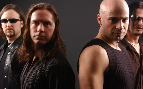 Four heavy-metal musicians in dark clothing and intense expressions against a black backdrop — HD music band portrait for PC desktop wallpaper.