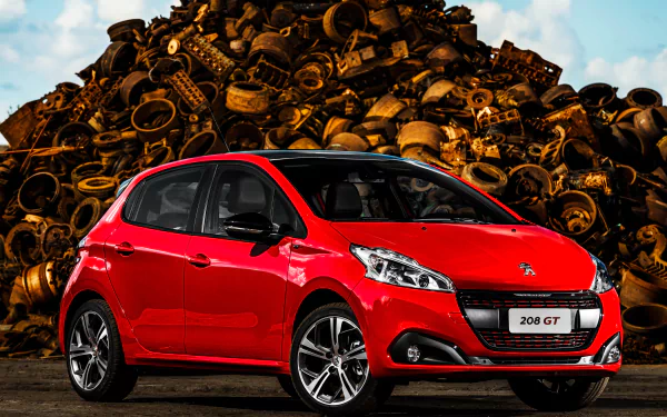 A red Peugeot 208 compact car with black roof details is parked in front of a large pile of tires, captured in a sharp 4K Ultra HD wallpaper image.