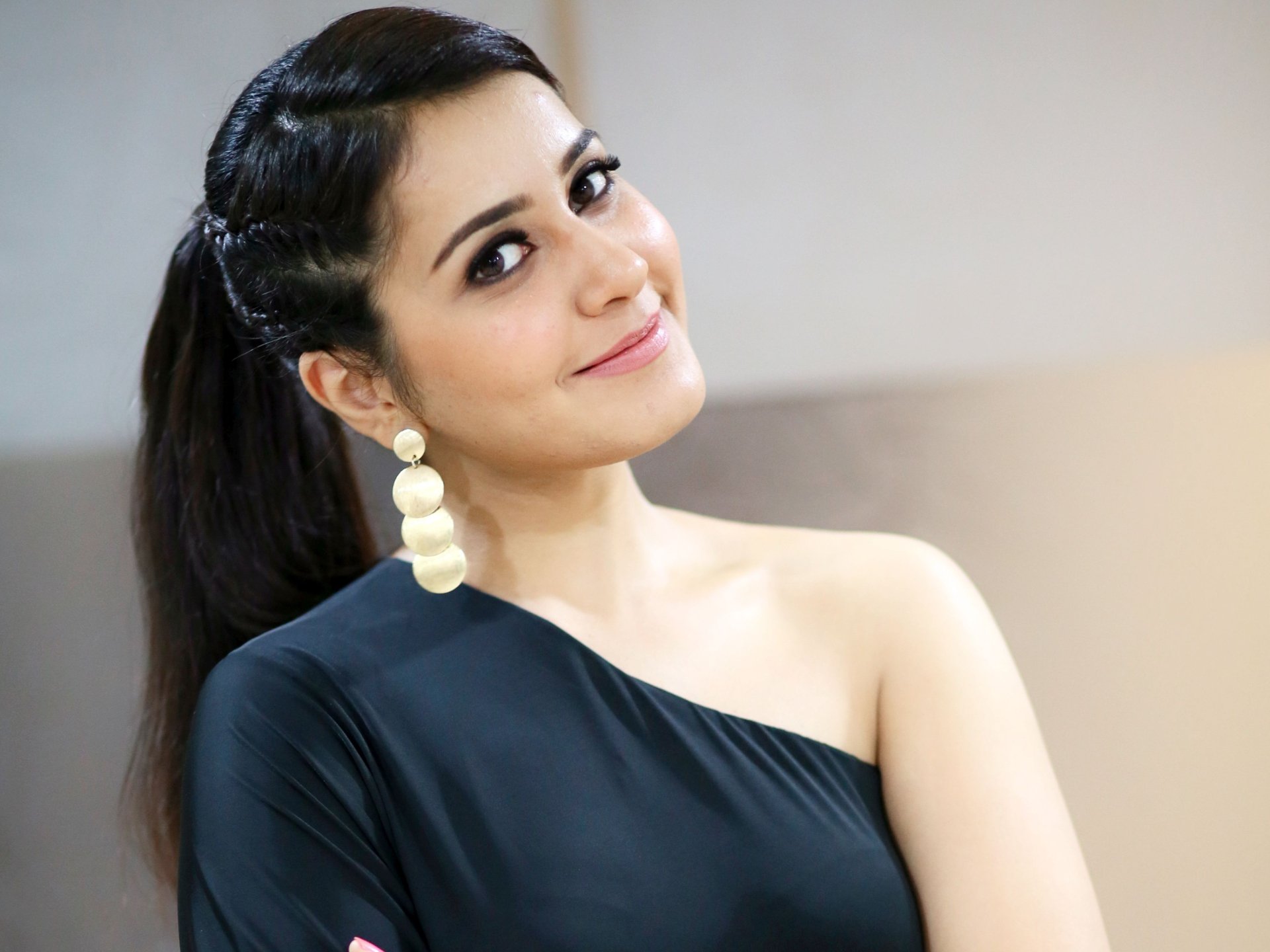 HD desktop wallpaper featuring celebrity Rashi Khanna. She is smiling warmly, wearing a stylish black off-shoulder dress and striking gold earrings.