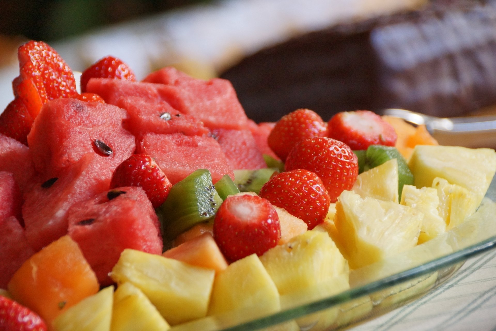 Vibrant fruit salad with pineapple, watermelon, strawberries, and kiwi, captured in stunning 4K Ultra HD for a fresh and colorful PC desktop wallpaper.
