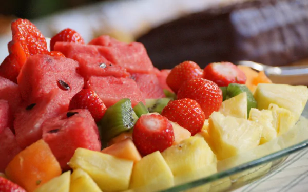 Vibrant fruit salad with pineapple, watermelon, strawberries, and kiwi, captured in stunning 4K Ultra HD for a fresh and colorful PC desktop wallpaper.