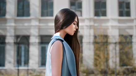 HD PC desktop wallpaper featuring a brunette woman model in a sleeveless blue vest, standing outdoors with an architectural background.
