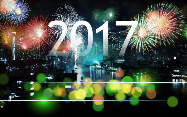 HD wallpaper featuring vibrant fireworks over a cityscape at night, with '2017' prominently displayed. The image captures the festive bokeh and celebratory spirit of New Year's Eve.