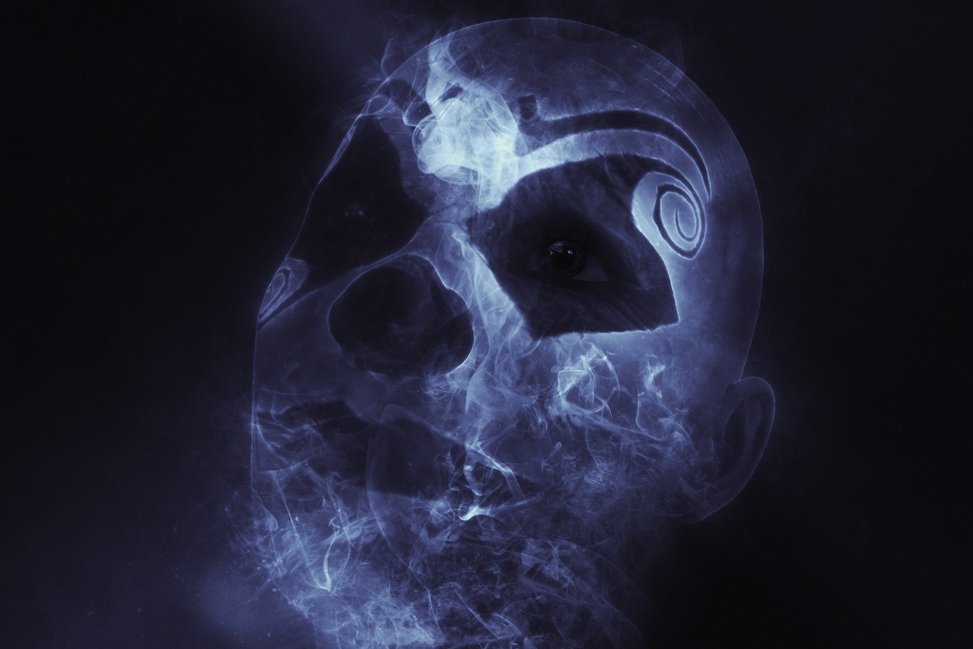 HD desktop wallpaper featuring a mystical, dark-themed clown face with eerie blue smoke effects, set against a pitch-black background.