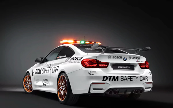 4K Ultra HD PC desktop wallpaper of a white BMW M4 DTM safety car race car, rear three-quarter view with roof lights, DTM livery and sporty alloy wheels.