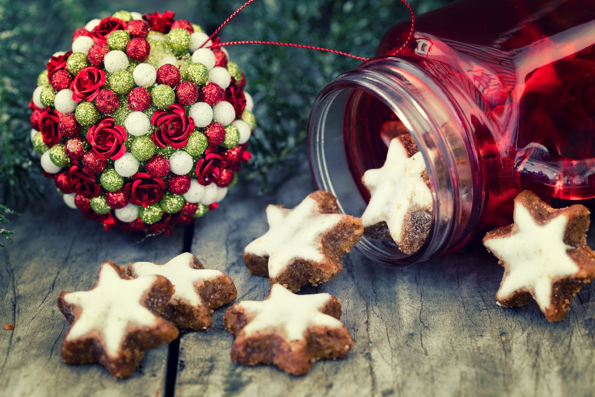 A 4K Ultra HD Christmas-themed desktop wallpaper featuring star-shaped cookies spilling from a jar beside a festive red and white ornament on a rustic wooden surface.
