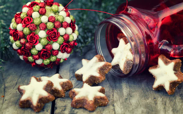 A 4K Ultra HD Christmas-themed desktop wallpaper featuring star-shaped cookies spilling from a jar beside a festive red and white ornament on a rustic wooden surface.