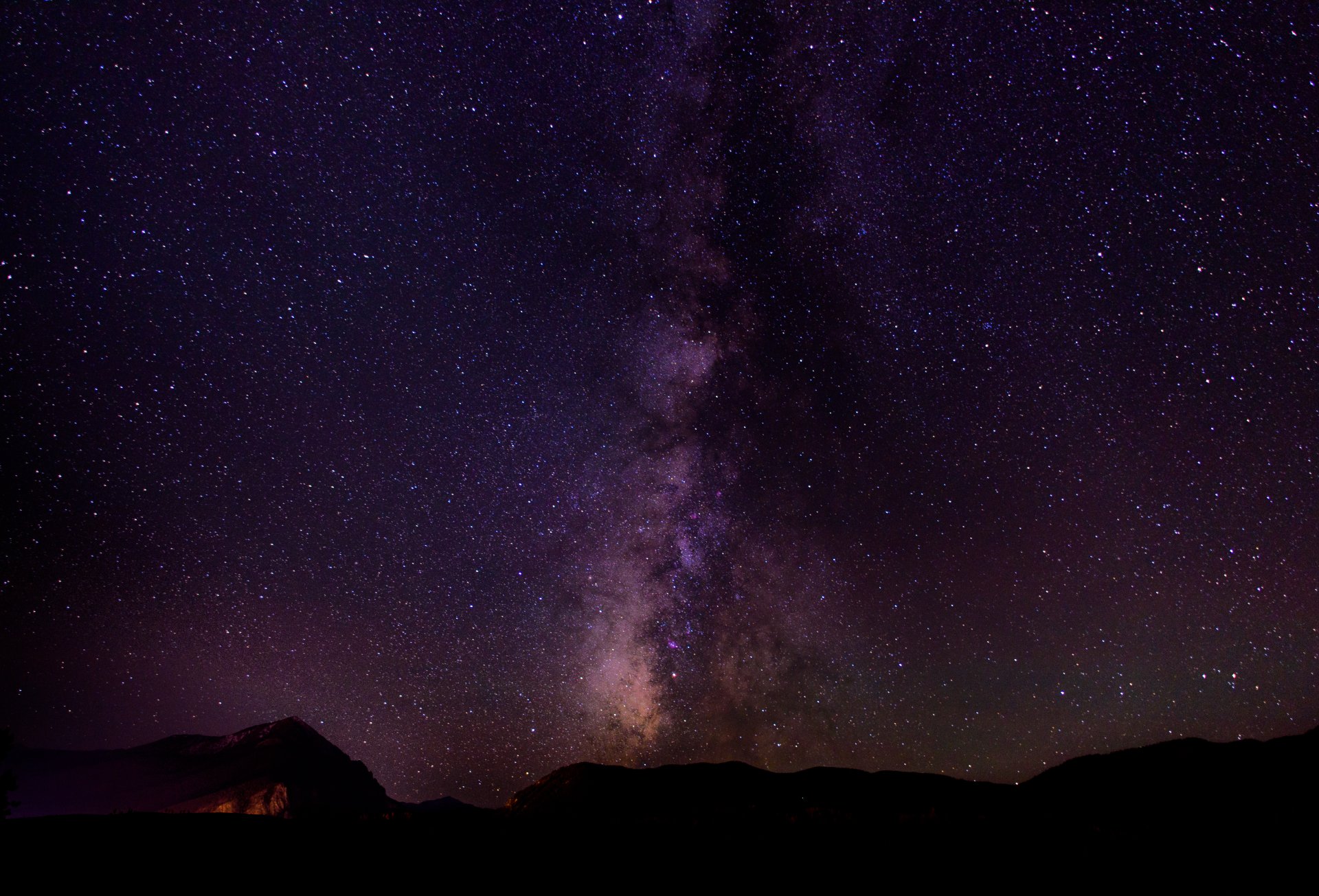 A stunning HD desktop wallpaper featuring a Sci-Fi inspired starry night sky with the Milky Way vividly stretching across the horizon above a silhouetted landscape.