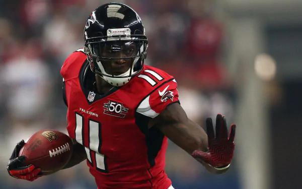 HD desktop wallpaper featuring a dynamic action shot of a football player in red and black uniform running on the field.