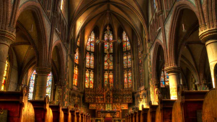 St Joseph's Cathedral interior, Groningen — illuminated Gothic nave with stained-glass windows and central Christian cross; religious church/cathedral presented as 4K Ultra HD PC desktop wallpaper.