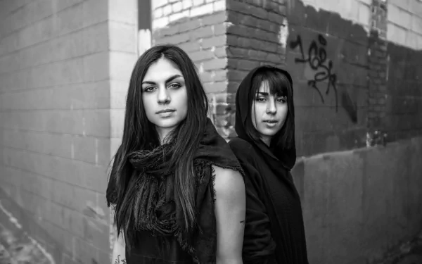 Black and white HD PC desktop wallpaper featuring music duo Krewella standing against an urban brick wall with graffiti in the background.