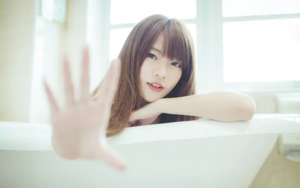 A brunette Asian woman posing in a bathtub, captured in a 4K Ultra HD PC desktop wallpaper and background.