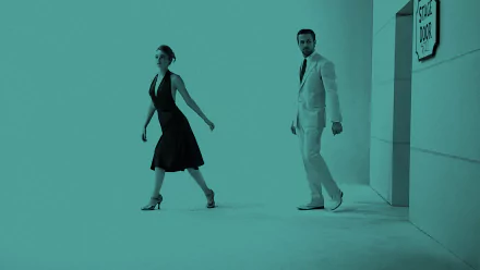 HD wallpaper of Ryan Gosling and Emma Stone from the movie La La Land. The image features both actors in formal attire, with a stylish monochrome background.
