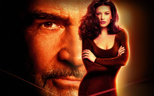 HD PC desktop wallpaper from the movie Entrapment, showing an intense close-up of a man's face beside a confident woman in a dark dress against a warm, glowing background.