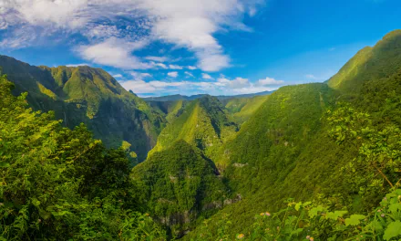 HD desktop wallpaper featuring lush, green mountains in France under a bright blue sky with scattered clouds, capturing the beauty of nature and greenery.