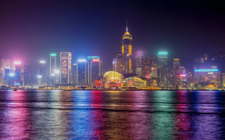 Vibrant nighttime Hong Kong skyline with colorful lit skyscrapers and waterfront reflections — 4K Ultra HD cityscape wallpaper highlighting modern man-made architecture in China.