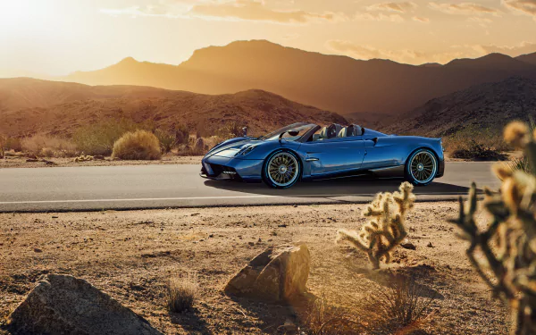 Blue Pagani Huayra supercar on a desert road at sunset, showcased as a high-definition PC desktop wallpaper and background.