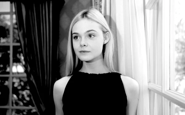 Black and white portrait of blonde American actress Elle Fanning, captured in a contemplative pose by a window, featured as an HD PC desktop wallpaper.