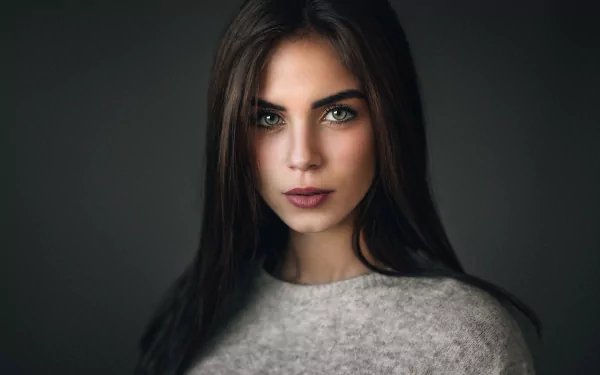 HD desktop wallpaper featuring a close-up portrait of a brunette woman with green eyes, identified as Marlen Valderrama Alvaréz, against a dark background.