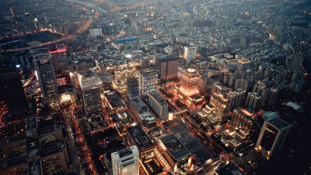 A vibrant cityscape featuring illuminated skyscrapers and urban buildings at dusk, captured in stunning 4K Ultra HD resolution for a dynamic PC desktop background.