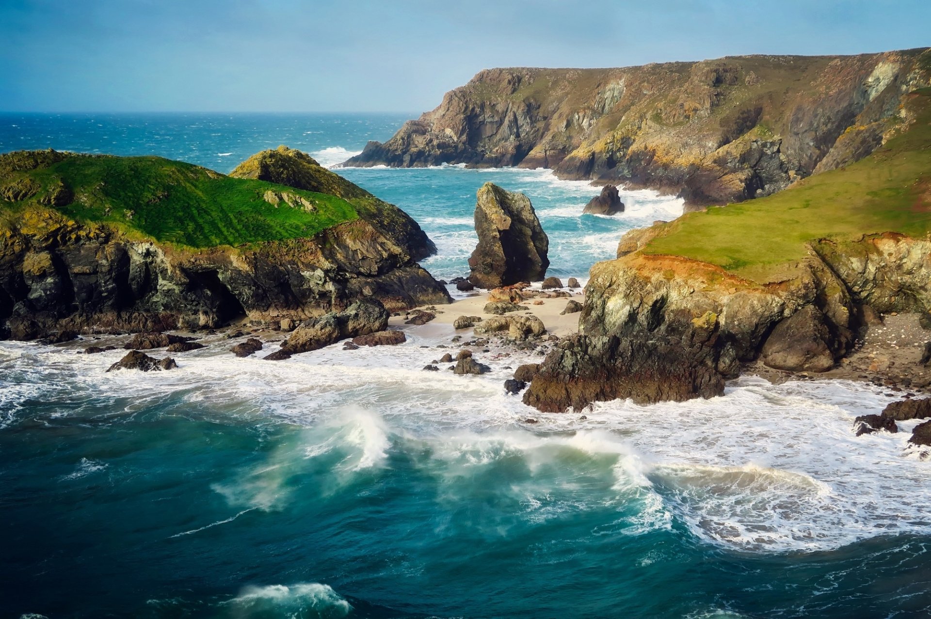 HD desktop wallpaper of a rugged coastline with crashing ocean foam, green cliffs, and a clear horizon under a bright sky, showcasing vibrant beach and nature scenery.