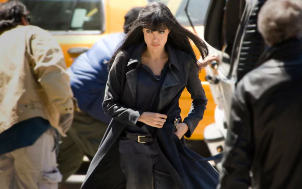 Angelina Jolie in character from the movie Salt, walking purposefully in a dark outfit, featured as an HD PC desktop wallpaper and background.
