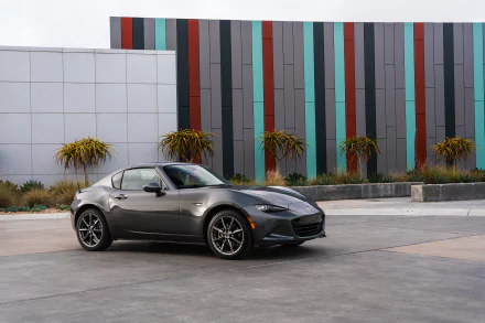 Silver Mazda MX-5 car parked in front of a colorful striped wall, captured in high definition as a sleek vehicle wallpaper background.