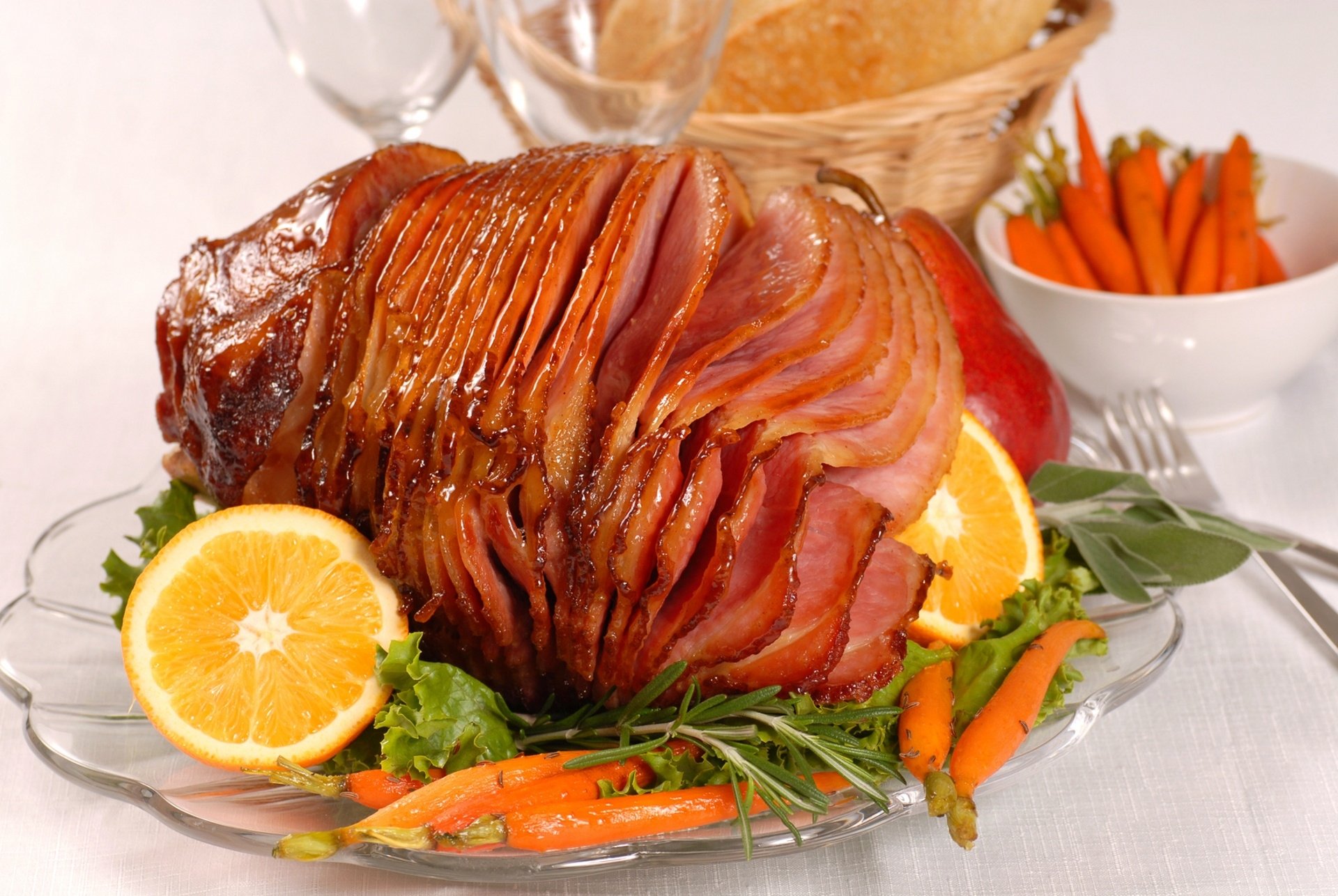 HD PC desktop wallpaper showing glazed spiral-cut ham on a platter with orange slices, baby carrots and greens — food, meat background.