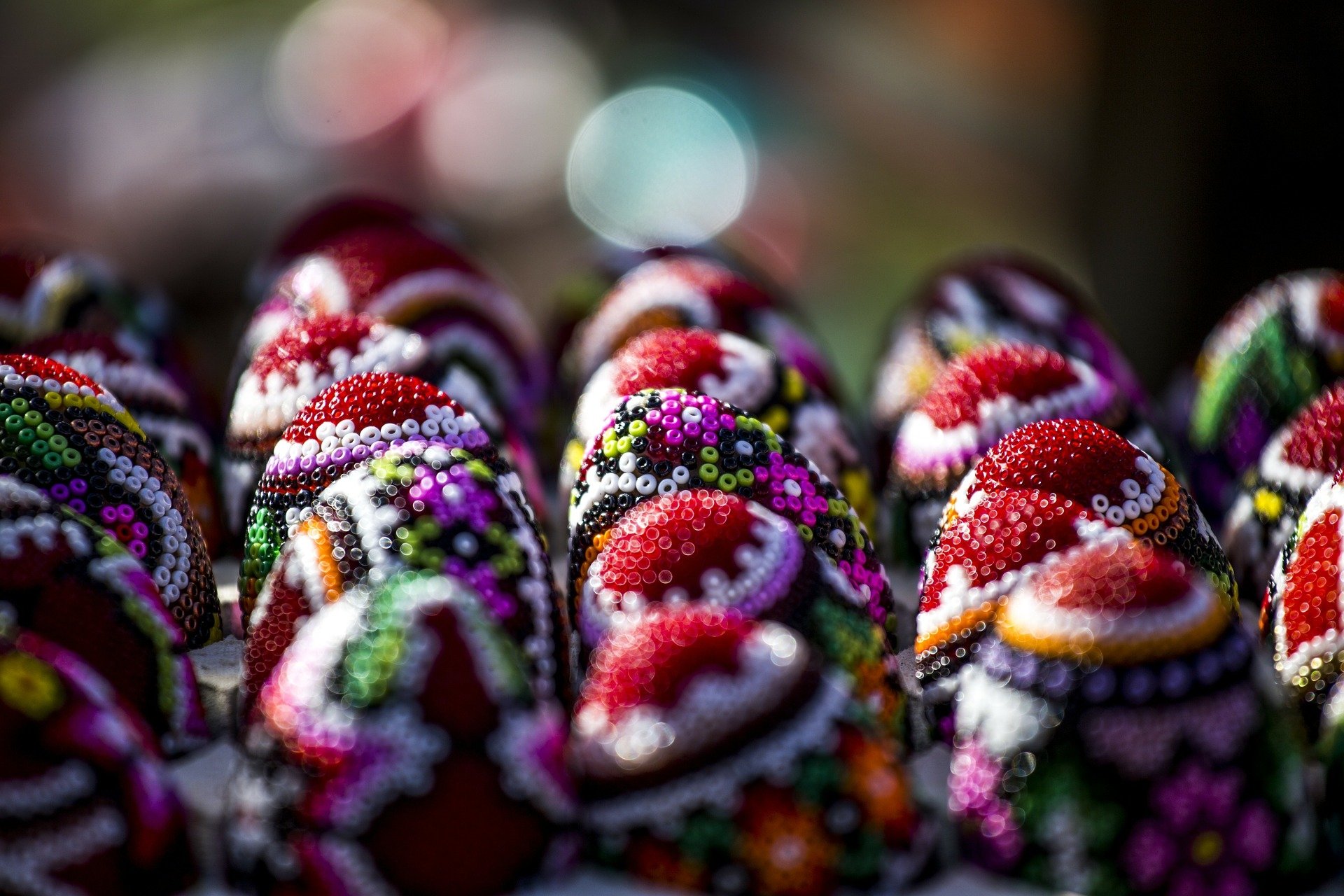 HD PC desktop wallpaper: close-up of colorful beaded Easter eggs with intricate patterns against a soft bokeh background — festive holiday Easter scene.