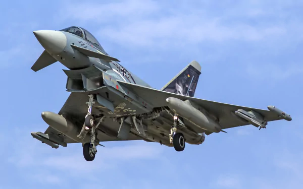 HD desktop wallpaper showing a Eurofighter Typhoon jet fighter in flight against a clear blue sky, highlighting its sleek military warplane design.