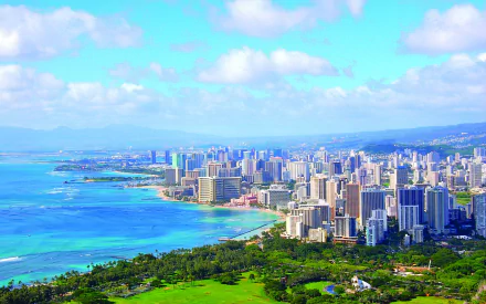 Hawaii Honolulu coastline cityscape: turquoise Pacific meets a man-made high-rise beachfront skyline and green parkland — 2K Quad HD desktop wallpaper.