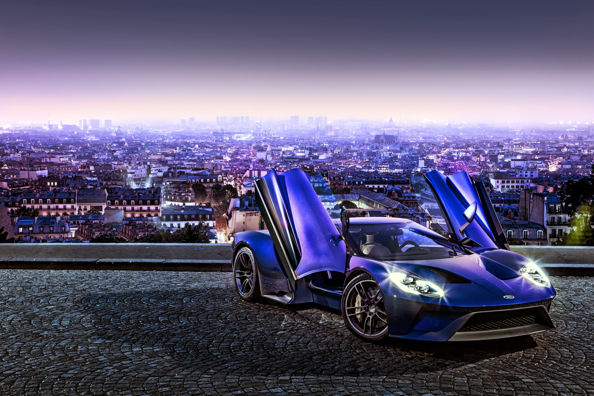 A striking Ford GT supercar with butterfly doors open, set against a sprawling cityscape at dusk in a vivid 4K Ultra HD PC desktop wallpaper.