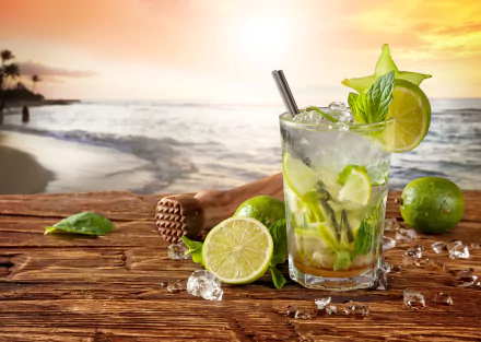 A refreshing glass of lime drink sits on a wooden surface, with vibrant limes nearby, against a tranquil ocean horizon and a soft sunset glow, creating an inviting still life scene.