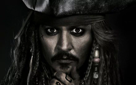 HD desktop wallpaper featuring Johnny Depp as Jack Sparrow from the movie Pirates of the Caribbean: Dead Men Tell No Tales, showing a close-up with intense gaze and pirate attire.