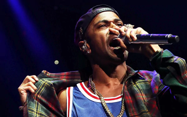 Big Sean performing passionately on stage, wearing a colorful outfit, captured in a dynamic moment. A vibrant HD desktop wallpaper celebrating music and artistry.