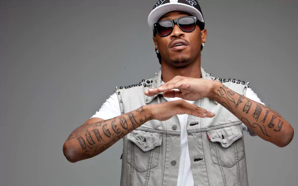 HD desktop wallpaper featuring a confident rapper with sunglasses and tattoos, embodying a futuristic vibe against a grey background.