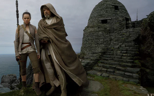 HD wallpaper featuring Mark Hamill as Luke Skywalker and Daisy Ridley as Rey from Star Wars: The Last Jedi, set against a rugged stone structure and cliffside.