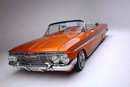HD desktop wallpaper featuring a classic orange Chevrolet Impala convertible lowrider with detailed chrome trim against a simple gray background.