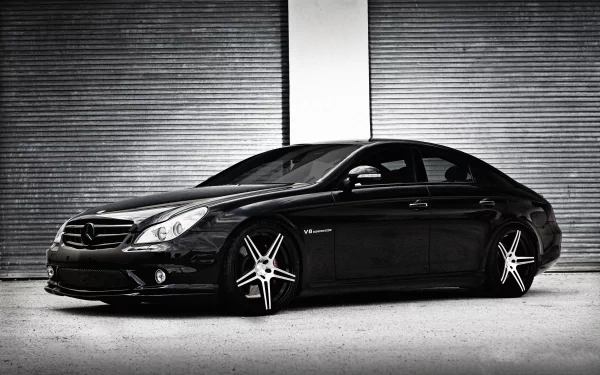 Black Mercedes-Benz CLS-Class car parked against a corrugated metal wall, shown in high-resolution 4K Ultra HD desktop wallpaper style.