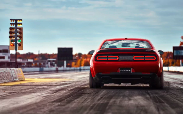 Rear view of a red Dodge Challenger SRT Demon muscle car on a drag strip under a clear sky, featured as an HD PC desktop wallpaper and background.