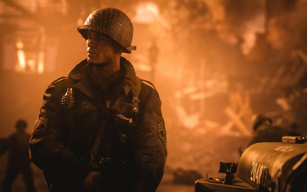 A soldier in WWII uniform stands amidst a fiery battlefield in this HD desktop wallpaper from Call of Duty: WWII.
