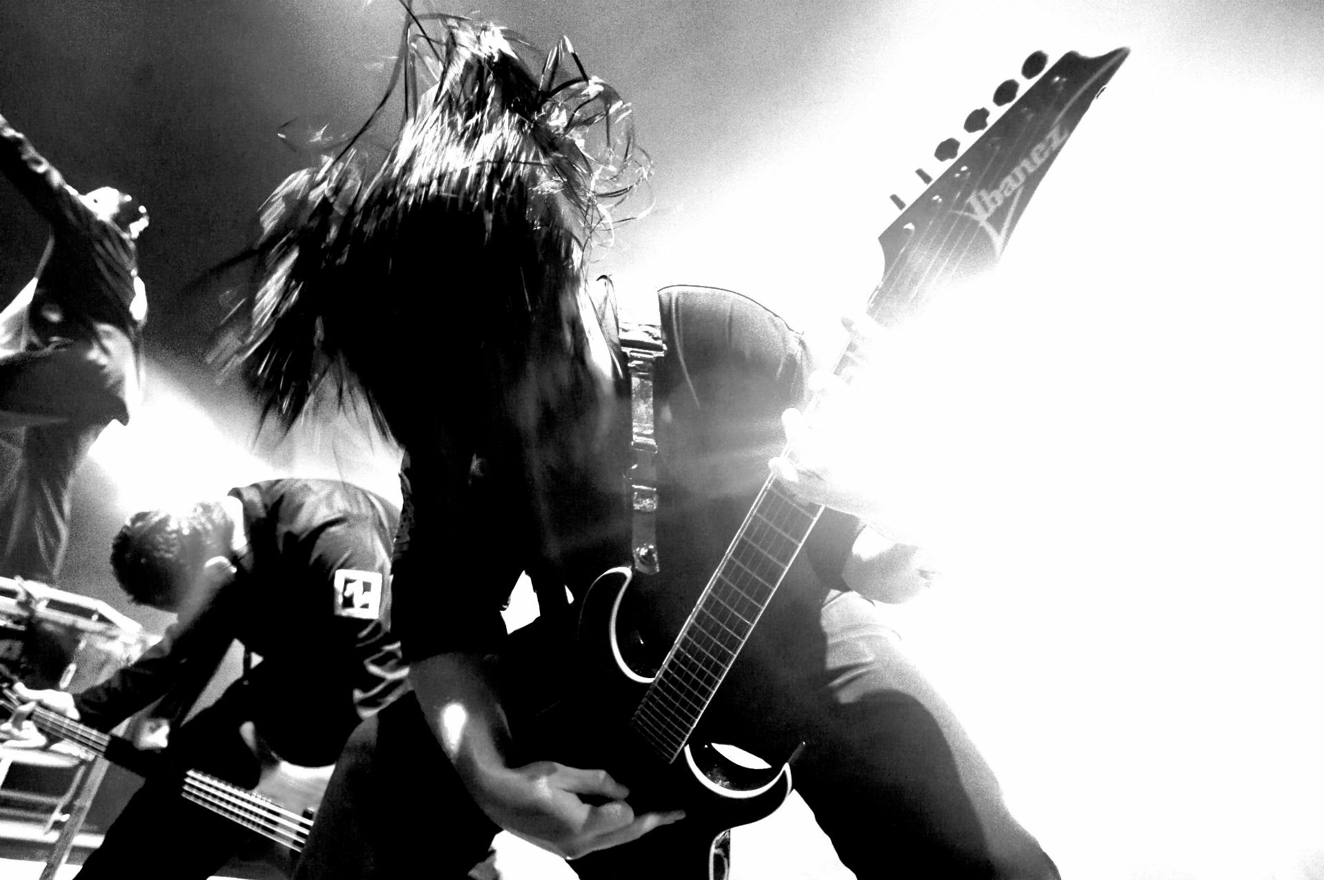 Black and white HD wallpaper of a heavy metal guitarist from Slipknot, capturing intense energy in an industrial and nu metal music vibe.