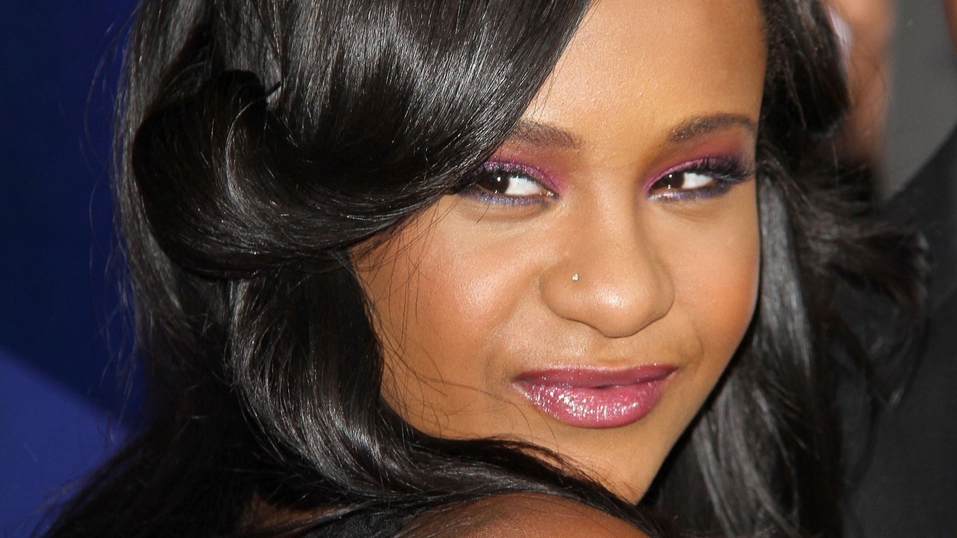 HD desktop wallpaper featuring a close-up of a woman with wavy hair and subtle makeup, providing a stylish background.